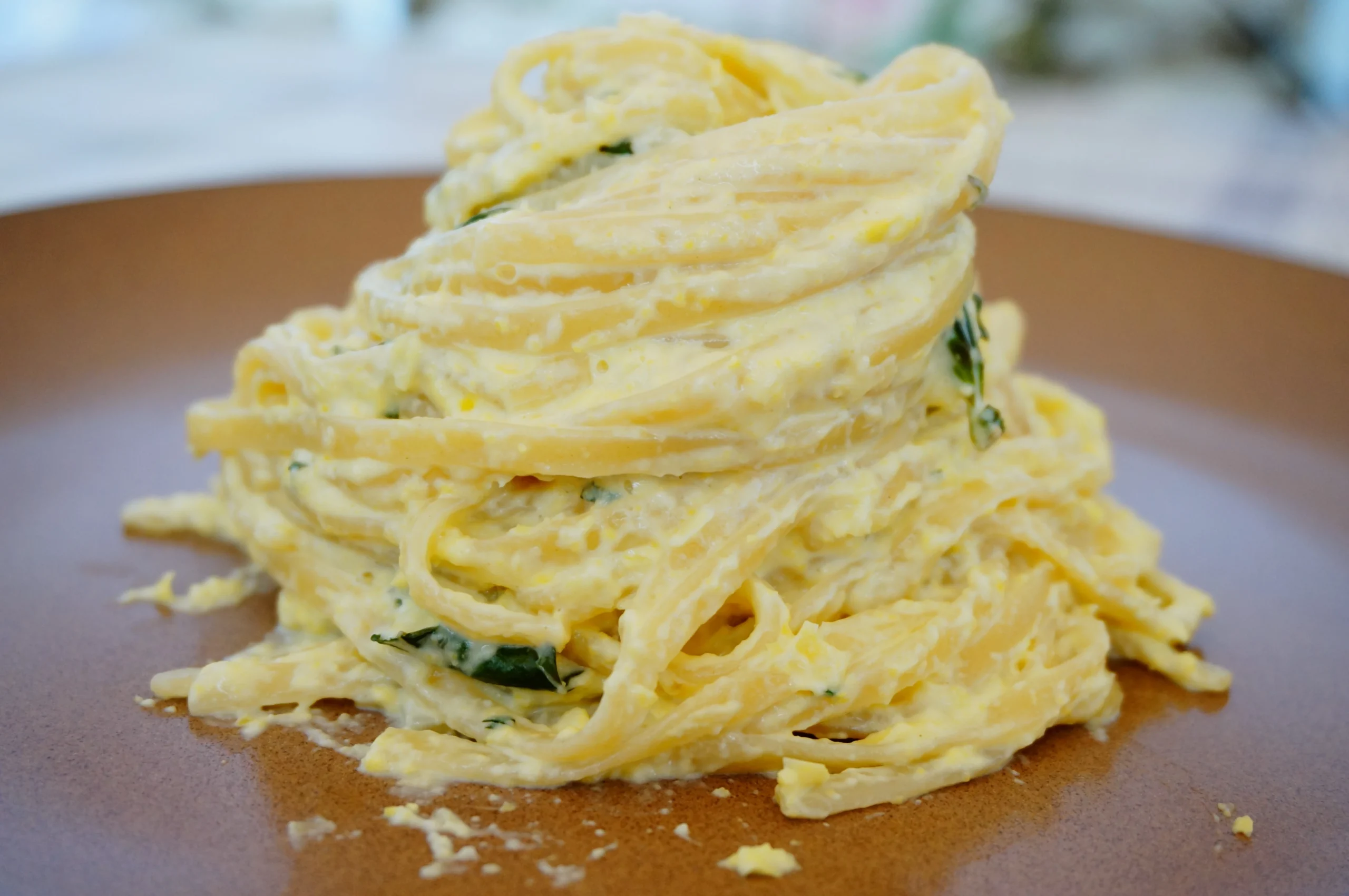 Лингвини с сырно-кукурузным соусом и базиликом крупным планом